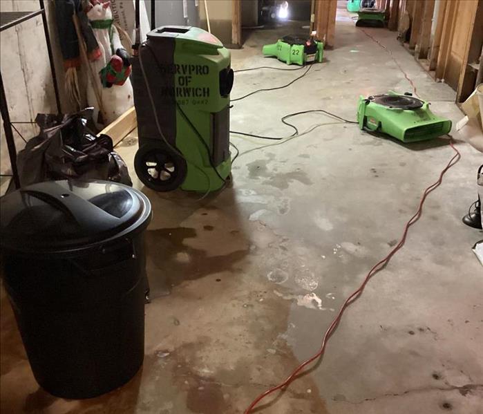 SERVPRO air movers and dehumidifiers drying the basement floor with most of the moisture now mitigated